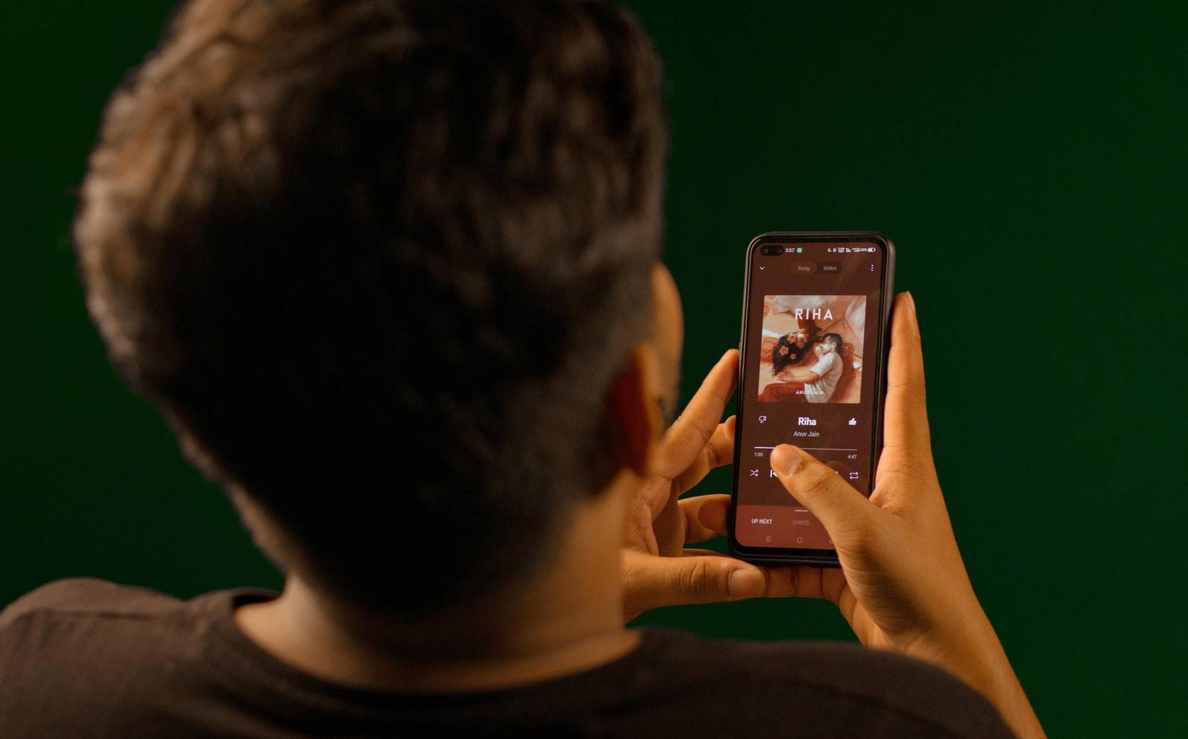 Person holding a mobile phone with the screen displaying text related to music and Instagram post instructions.